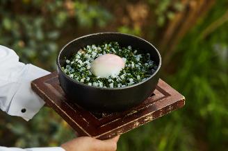 A person holding a bowl of food

Description automatically generated