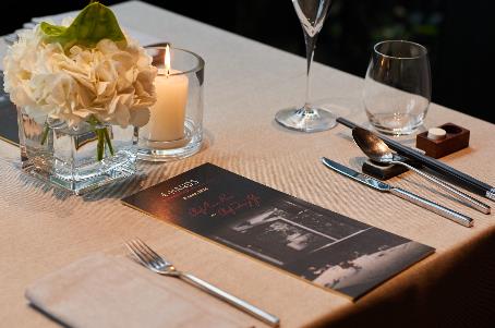 A table with a menu and candles Description automatically generated
