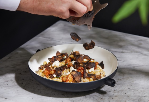A person putting food into a bowl

Description automatically generated