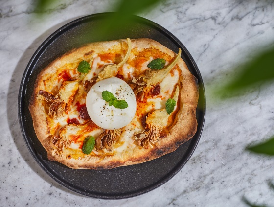 A pizza on a plate
Description automatically generated
