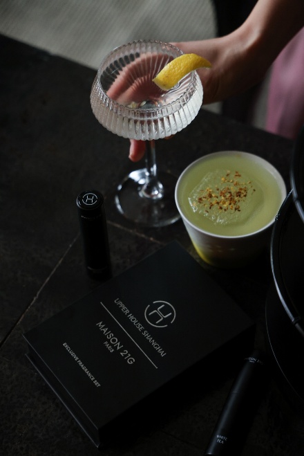 A person holding a glass of drink Description automatically generated