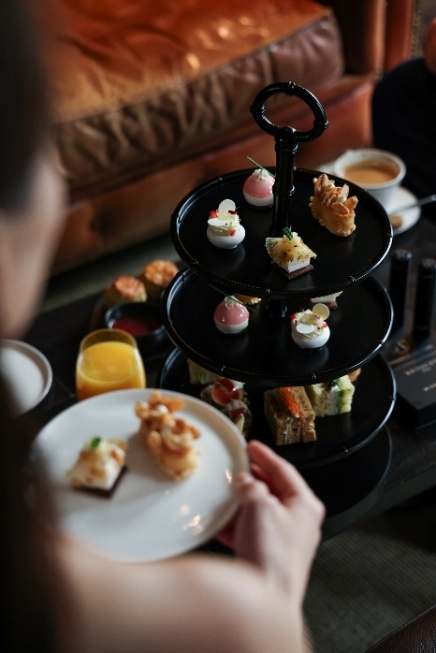 A person holding a plate of desserts Description automatically generated